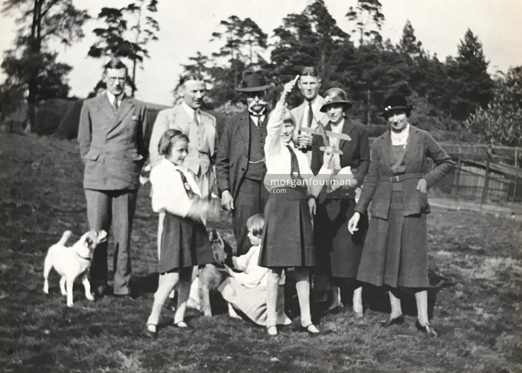 The gardens of Elm Lodge, c. 1930. Probably taken by Mary Downing after weekly Sunday tea with the Downing grandparents. From left: Glyn Williams, Hazel, Noel, Roby the spaniel, W.E. Downing, Jill, Pamela, Jack and Daisy Grazebrook, Molly